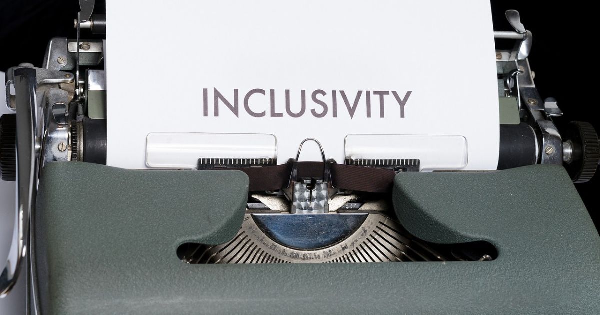 Eine Schreibmaschine mit einem weißen Blatt Papier und dem Text Inclusivity.
