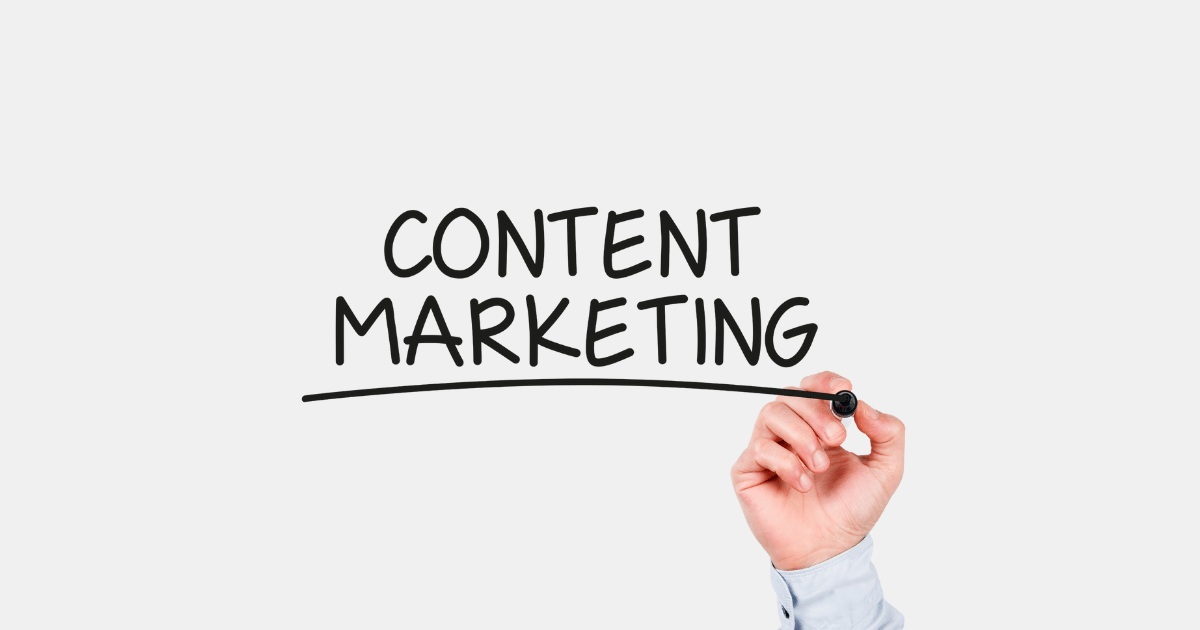 Eine rechte Hand schreibt mit einem schwarzen Stift Content Marketing