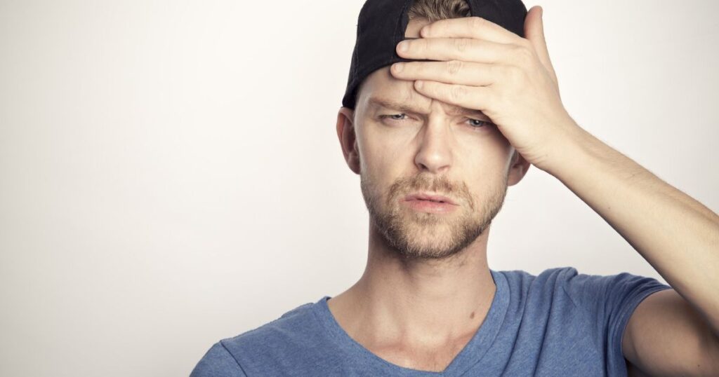 Ein Mann mit sorgendem Blick greift sich mit sorgendem Blick an die Stirn, weil er keine Website Flatrate hat.