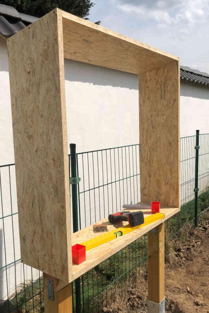 Ein Holzrahmen aus Spanplatten wurde auf den Sockel aufgesetzt.